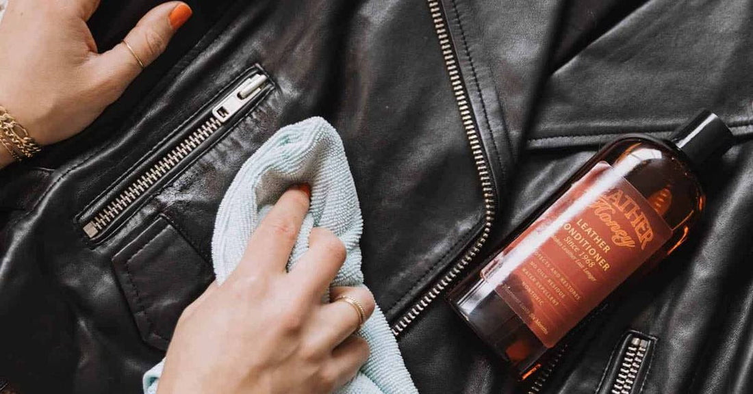 Person applying leather conditioner to premium genuine leather jacket for proper maintenance