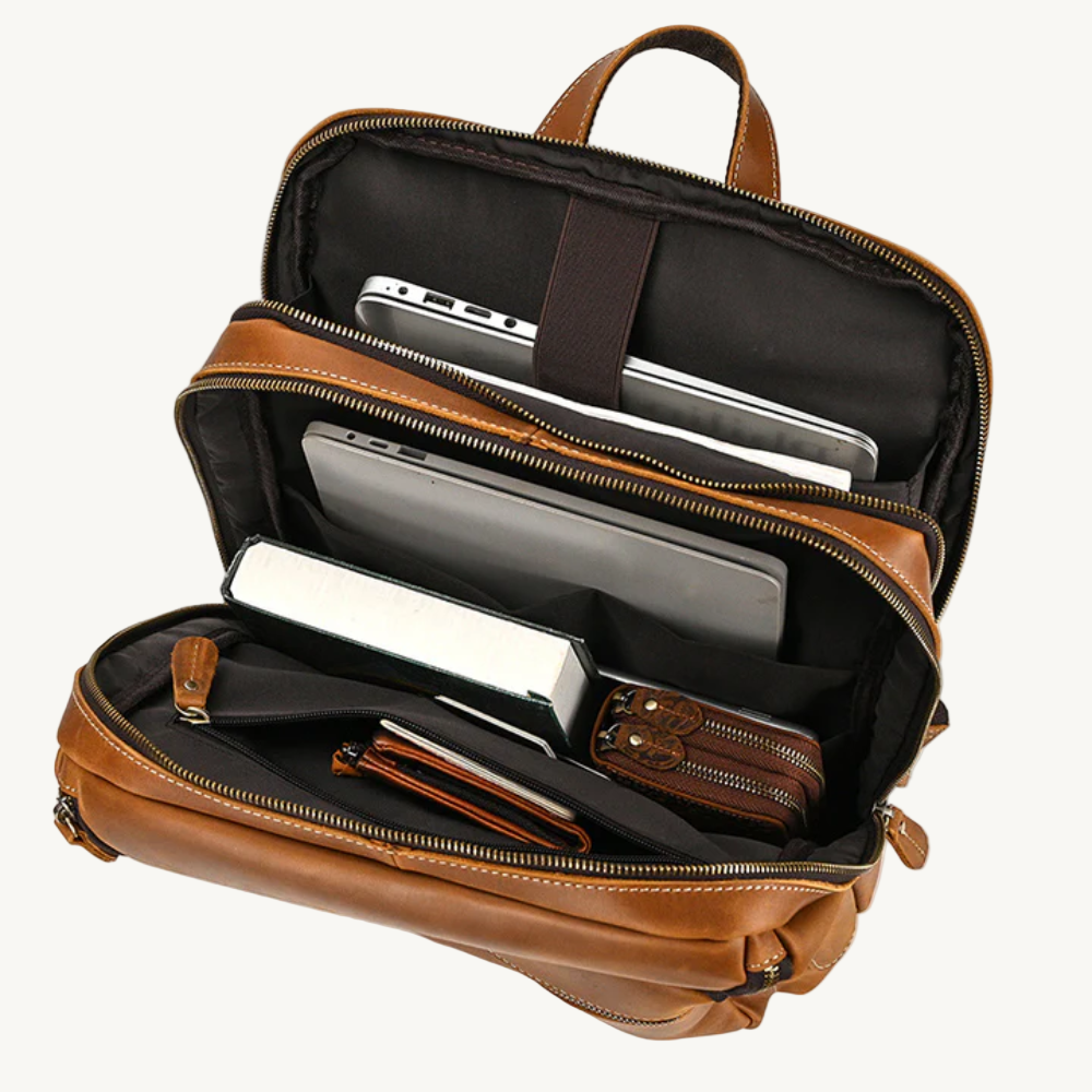 Brown leather backpack with compartments containing electronic devices on a white background